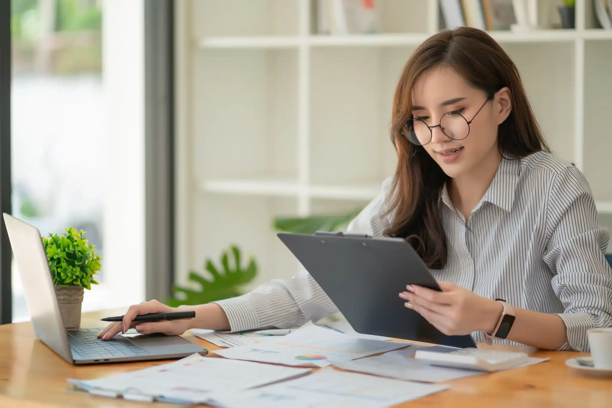 working woman looking document working desk with laptop computer paperwork concept scaled