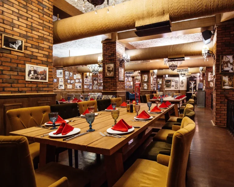 restaurant hall with red brick walls wooden tables pipes ceiling Web V